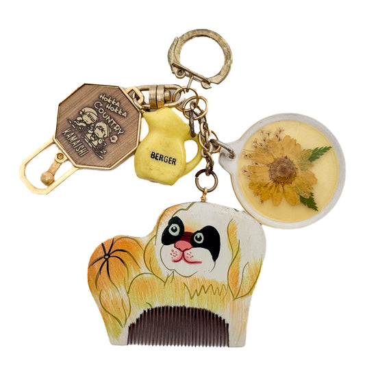 miki yamamoto「キーリング “Yellow Dog”」犬の絵が描かれた櫛、押し花、黄色い水差し、ヴィンテージの金属チャームなどを組み合わせた一点もののキーリング。