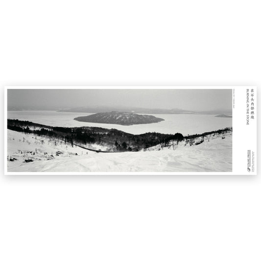 宛超凡『Hokkaido February, 2021』写真ポスター。雪に覆われた斜面から湖と中島を望むモノクロームの風景写真。写真集『Burning In The Stone IV』収録作品、STAIRS PRESS刊。